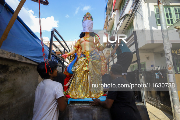 Nepali Hindu devotees load a clay statue of a Hindu deity into a vehicle from a studio in Lalitpur, Nepal, on October 2, 2024. 