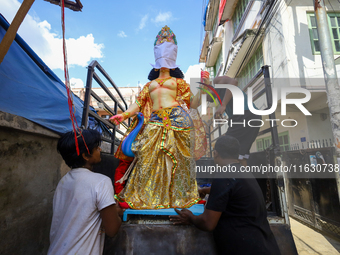 Nepali Hindu devotees load a clay statue of a Hindu deity into a vehicle from a studio in Lalitpur, Nepal, on October 2, 2024. (