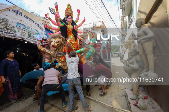 Nepali Hindu devotees load a clay statue of a Hindu deity into a vehicle from a studio in Lalitpur, Nepal, on October 2, 2024. Statues of Go...