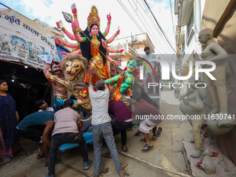 Nepali Hindu devotees load a clay statue of a Hindu deity into a vehicle from a studio in Lalitpur, Nepal, on October 2, 2024. Statues of Go...