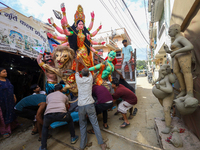 Nepali Hindu devotees load a clay statue of a Hindu deity into a vehicle from a studio in Lalitpur, Nepal, on October 2, 2024. Statues of Go...