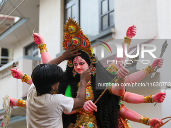 A local artist decorates the idol of Hindu Goddess Durga at his studio in Lalitpur, Nepal, on October 2, 2024. Nepal, along with India, cele...