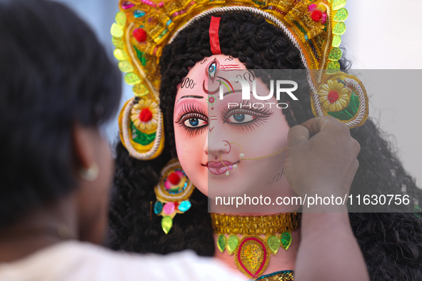 A local artist decorates the idol of Hindu Goddess Durga at his studio in Lalitpur, Nepal, on October 2, 2024. Nepal, along with India, cele...