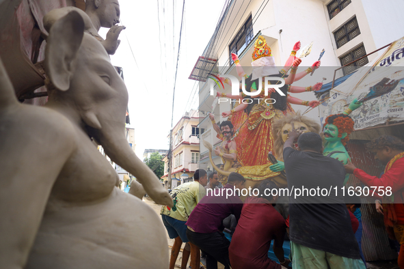 Nepali Hindu devotees load a clay statue of a Hindu deity into a vehicle from a studio in Lalitpur, Nepal, on October 2, 2024. Statues of Go...