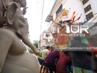 Nepali Hindu devotees load a clay statue of a Hindu deity into a vehicle from a studio in Lalitpur, Nepal, on October 2, 2024. Statues of Go...