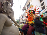 Nepali Hindu devotees load a clay statue of a Hindu deity into a vehicle from a studio in Lalitpur, Nepal, on October 2, 2024. Statues of Go...