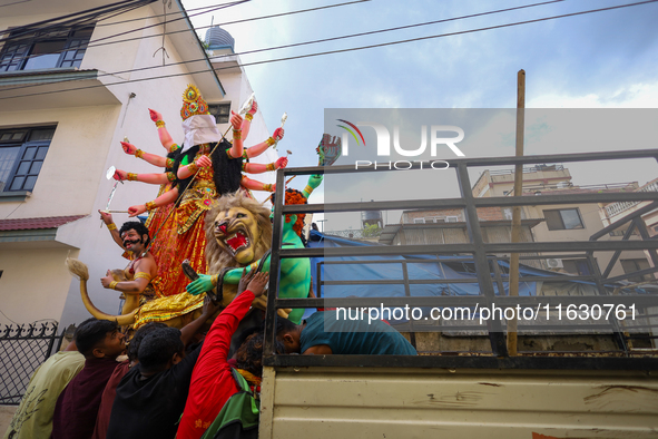 Nepali Hindu devotees load a clay statue of a Hindu deity into a vehicle from a studio in Lalitpur, Nepal, on October 2, 2024. Statues of Go...