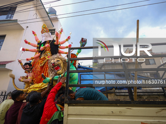 Nepali Hindu devotees load a clay statue of a Hindu deity into a vehicle from a studio in Lalitpur, Nepal, on October 2, 2024. Statues of Go...