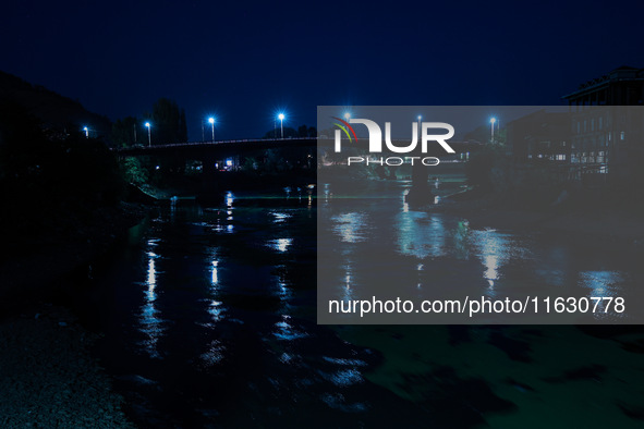 Vehicles move on a bridge as street lights glow during an evening in Baramulla, Jammu and Kashmir, India, on October 2, 2024. 