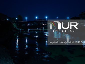 Vehicles move on a bridge as street lights glow during an evening in Baramulla, Jammu and Kashmir, India, on October 2, 2024. (