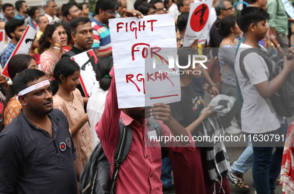 Doctors and citizens hold placards and shout slogans during a protest march against the rape and murder of a PGT woman doctor at Government-...