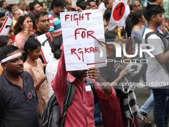 Doctors and citizens hold placards and shout slogans during a protest march against the rape and murder of a PGT woman doctor at Government-...