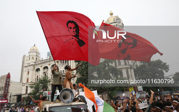 Doctors and citizens hold placards and shout slogans while marching with burning torches during a protest against the rape and murder of a P...