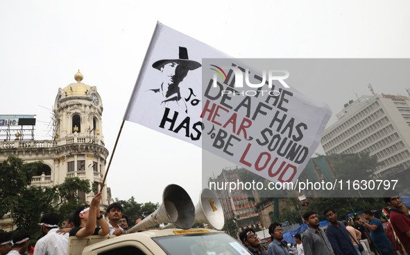 Doctors and citizens hold placards and shout slogans while marching with burning torches during a protest against the rape and murder of a P...