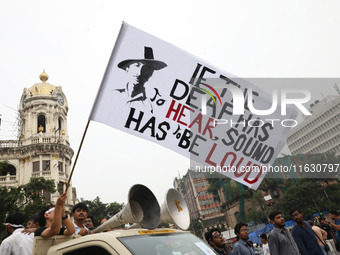 Doctors and citizens hold placards and shout slogans while marching with burning torches during a protest against the rape and murder of a P...