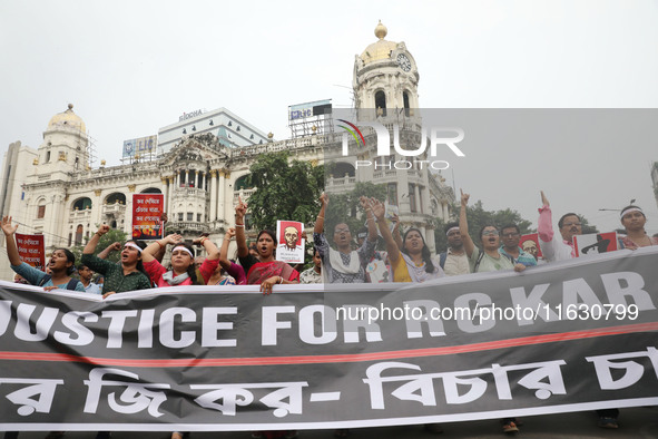 Doctors and citizens hold placards and shout slogans while marching with burning torches during a protest against the rape and murder of a P...