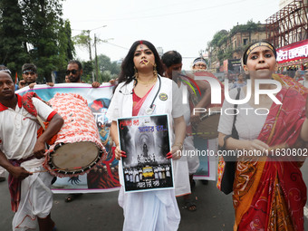 A woman dresses as a doctor and Hindu goddess Durga while doctors and citizens hold placards and shout slogans during a protest march with b...