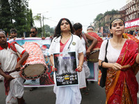 A woman dresses as a doctor and Hindu goddess Durga while doctors and citizens hold placards and shout slogans during a protest march with b...