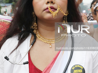 A woman dresses as a doctor and Hindu goddess Durga while doctors and citizens hold placards and shout slogans during a protest march with b...