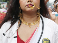 A woman dresses as a doctor and Hindu goddess Durga while doctors and citizens hold placards and shout slogans during a protest march with b...