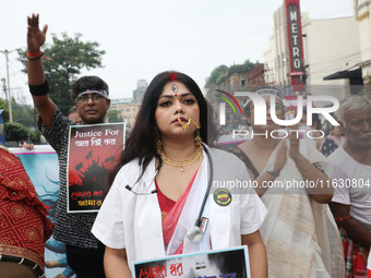 A woman dresses as a doctor and Hindu goddess Durga while doctors and citizens hold placards and shout slogans during a protest march with b...