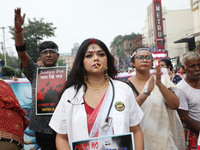 A woman dresses as a doctor and Hindu goddess Durga while doctors and citizens hold placards and shout slogans during a protest march with b...