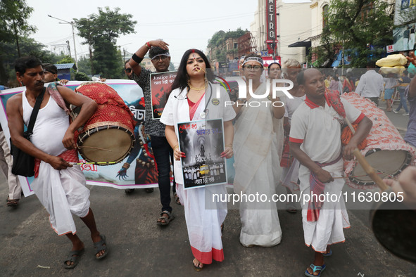 A woman dresses as a doctor and Hindu goddess Durga while doctors and citizens hold placards and shout slogans during a protest march with b...