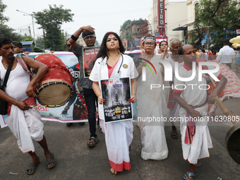 A woman dresses as a doctor and Hindu goddess Durga while doctors and citizens hold placards and shout slogans during a protest march with b...