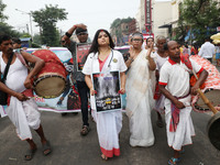 A woman dresses as a doctor and Hindu goddess Durga while doctors and citizens hold placards and shout slogans during a protest march with b...