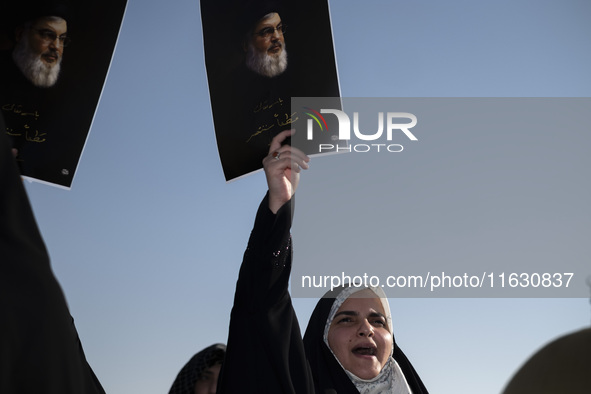 Veiled Iranian women hold portraits of Lebanon's Hezbollah Secretary General Hassan Nasrallah, who was killed in an Israeli airstrike in the...