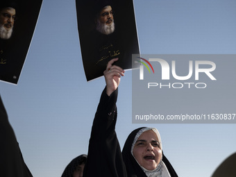 Veiled Iranian women hold portraits of Lebanon's Hezbollah Secretary General Hassan Nasrallah, who was killed in an Israeli airstrike in the...