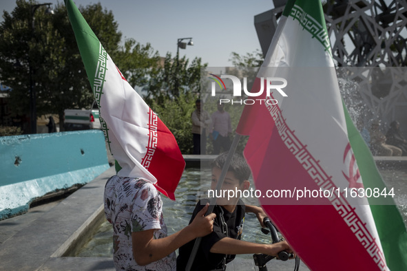 Two young Iranian boys hold Iranian flags while taking part in a gathering marking the memory of Lebanon's Hezbollah Secretary General Hassa...