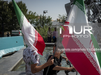 Two young Iranian boys hold Iranian flags while taking part in a gathering marking the memory of Lebanon's Hezbollah Secretary General Hassa...