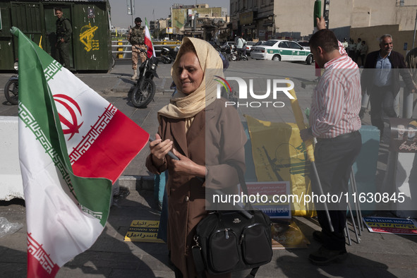 An Iranian woman carries an Iranian flag before a gathering marking the memory of Lebanon's Hezbollah Secretary General, Hassan Nasrallah, a...