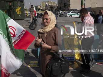 An Iranian woman carries an Iranian flag before a gathering marking the memory of Lebanon's Hezbollah Secretary General, Hassan Nasrallah, a...