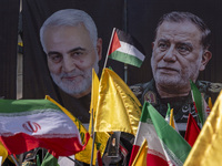 Iranian people wave a Palestinian flag, an Iranian flag, and flags of Lebanon's Hezbollah in front of portraits of the former commander of t...