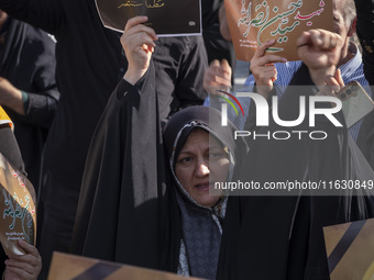 A veiled Iranian woman holds a portrait of Lebanon's Hezbollah Secretary General Hassan Nasrallah while shouting anti-Israeli slogans during...