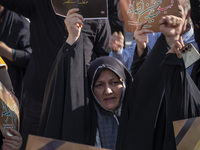 A veiled Iranian woman holds a portrait of Lebanon's Hezbollah Secretary General Hassan Nasrallah while shouting anti-Israeli slogans during...