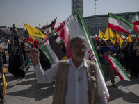 Iranian people wave Iranian flags and Lebanon's Hezbollah flags during a gathering marking the memory of Hezbollah Leader Hassan Nasrallah a...