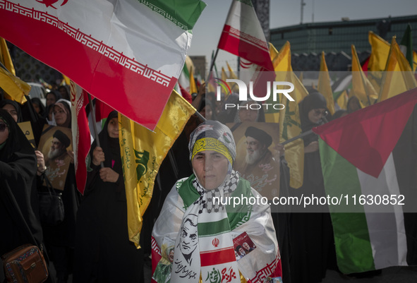 An Iranian woman wearing an Iranian flag looks on while taking part in a gathering marking the memory of Lebanon's Hezbollah Secretary Gener...