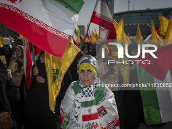 An Iranian woman wearing an Iranian flag looks on while taking part in a gathering marking the memory of Lebanon's Hezbollah Secretary Gener...