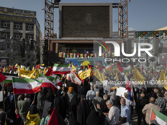 Iranian people wave flags of Lebanon's Hezbollah and Iranian flags during a gathering marking the memory of Nasrallah and an Iranian command...