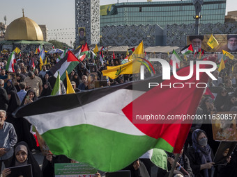 An Iranian man (not pictured) waves a Palestinian flag as others hold portraits of Lebanon's Hezbollah Secretary General Hassan Nasrallah du...