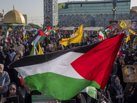 An Iranian man (not pictured) waves a Palestinian flag as others hold portraits of Lebanon's Hezbollah Secretary General Hassan Nasrallah du...