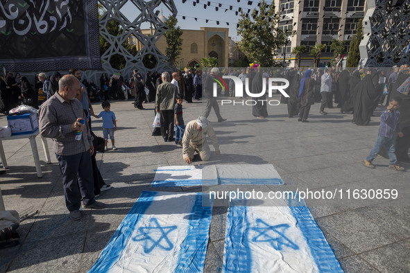 An Iranian man prepares Israeli flags to be set on fire during a gathering marking the memory of Lebanon's Hezbollah Secretary General Hassa...