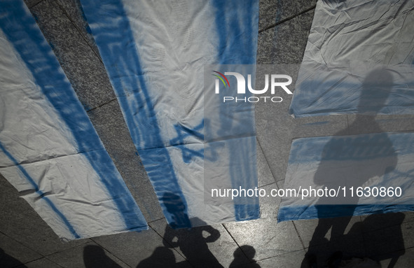 Iranian people stand next to Israeli flags that are prepared to set on fire during a gathering marking the memory of Lebanon's Hezbollah Sec...