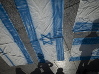 Iranian people stand next to Israeli flags that are prepared to set on fire during a gathering marking the memory of Lebanon's Hezbollah Sec...