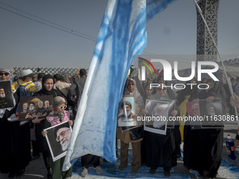 An Iranian man holds an Israeli flag while women and children hold portraits of Lebanon's Hezbollah Secretary General Hassan Nasrallah, form...