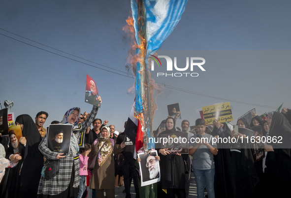 An Iranian man (not pictured) burns an Israeli flag while women hold portraits of Lebanon's Hezbollah Secretary General Hassan Nasrallah, fo...