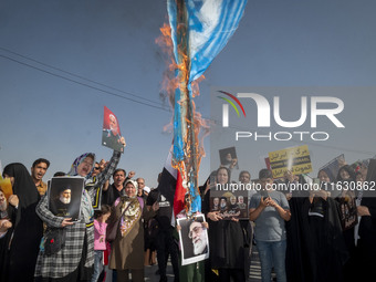 An Iranian man (not pictured) burns an Israeli flag while women hold portraits of Lebanon's Hezbollah Secretary General Hassan Nasrallah, fo...